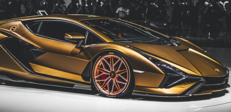Златист Lamborghini суперавтомобил на изложение с публика на заден план