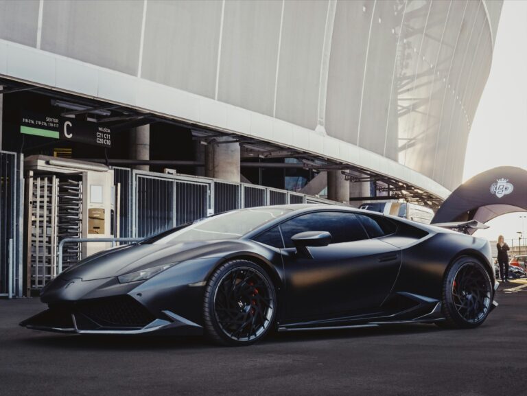 Черно матово Lamborghini Huracán паркирано пред модерен стадион